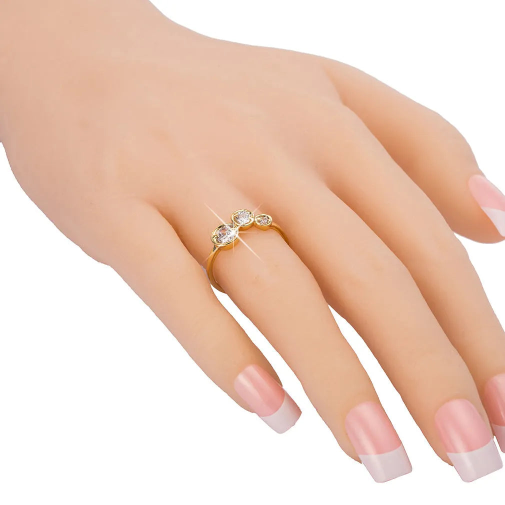 Three copper electroplated rings with lotus leaf design and round zircon stones in gold white zirconium tone on a flat surface