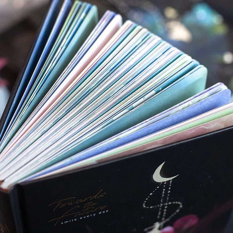 A5 notebook with luminous cover open to show colour illustrated interior pages