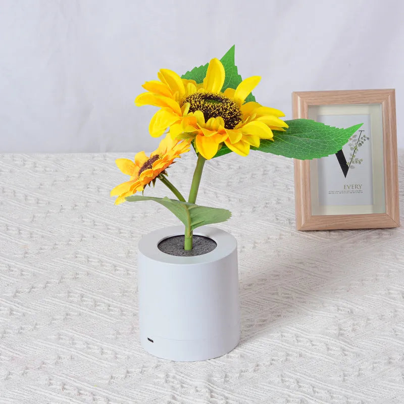 Rechargeable artificial sunflower LED night light on a table with USB cable.