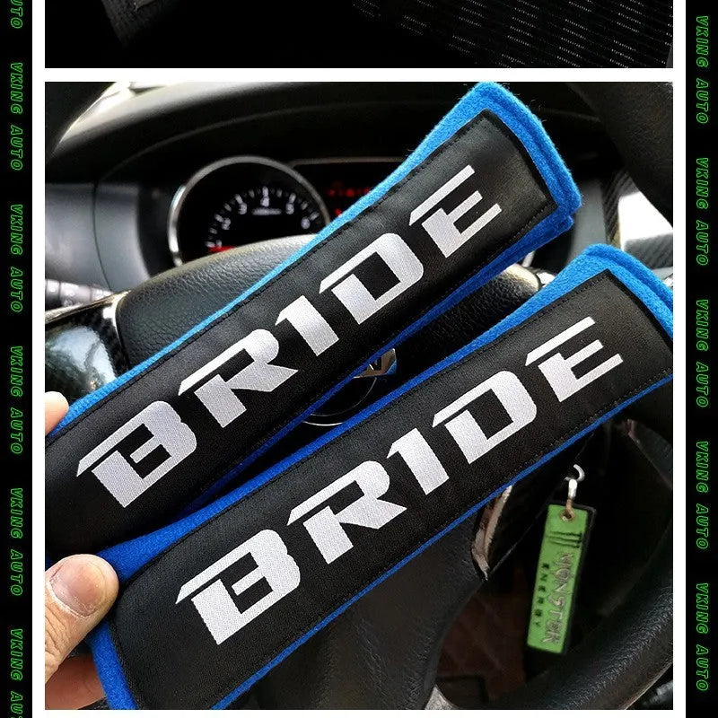 Pair of black car safety belt shoulder pads showing sponge cloth padding and embroidery detail