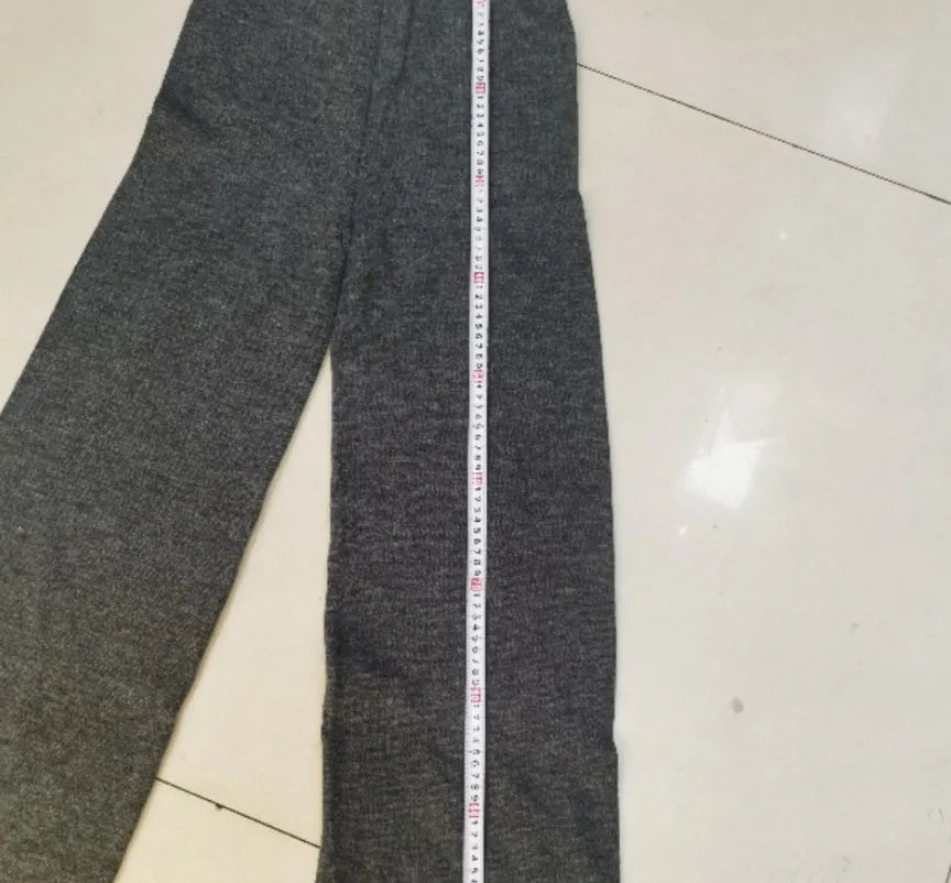 Women's dark grey acrylic knit sweater suit with side-slit top and matching trousers.