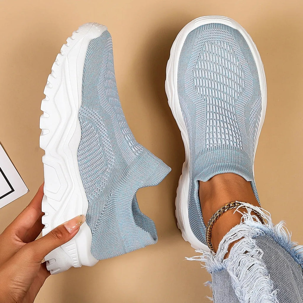 Light blue women's mesh slip-on sports shoes with a round toe and mid heel on a white background.