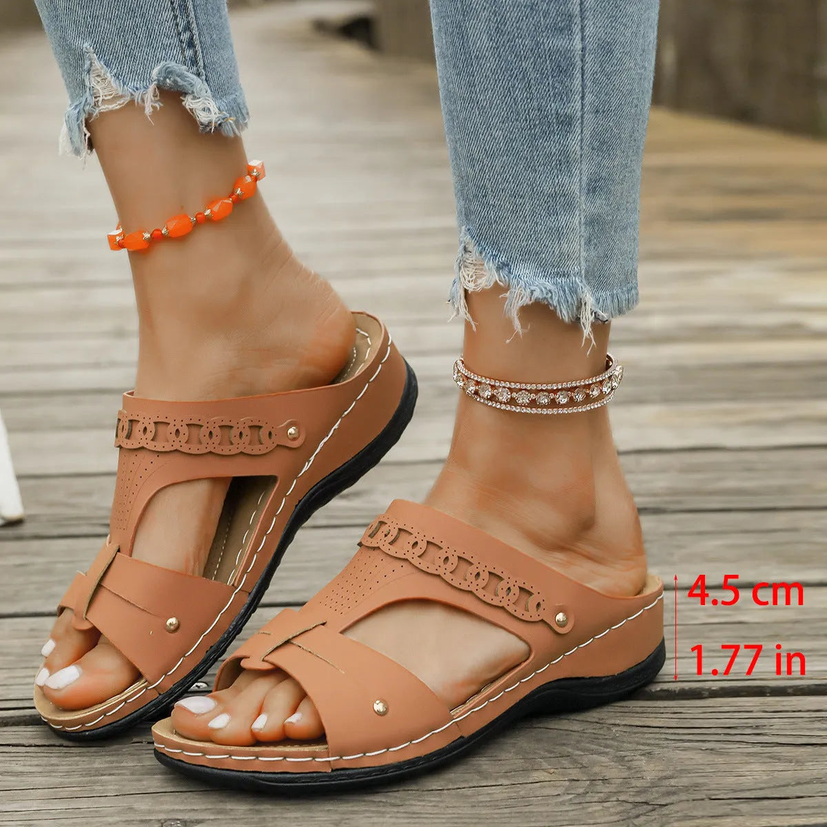 Women's blue Roman style slope heel slippers with fish mouth toe holder on a wooden floor.