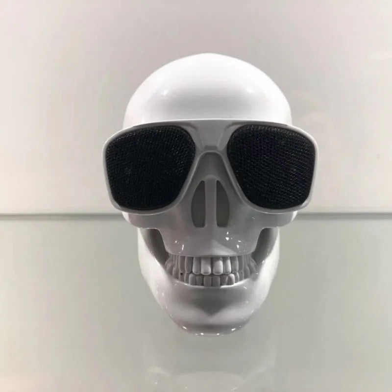 Small skull-shaped wireless Bluetooth speaker in black, portable with button controls and USB charging