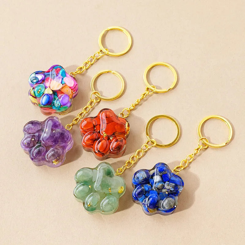 Small natural crystal cat's paw shaped pendant on a keychain ring, shown in various crystal colour options.