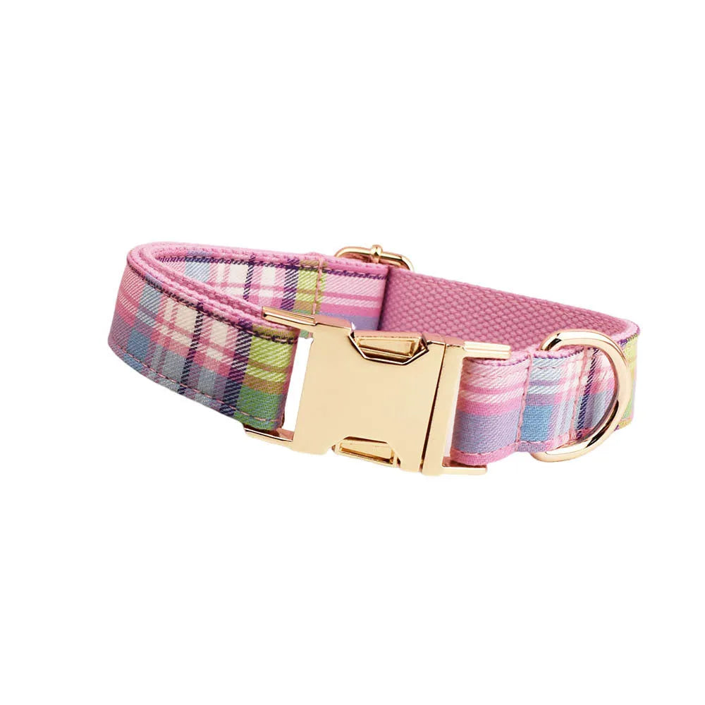Cloth dog collar and matching lead set with a red bow and a matching dog vest laid out flat.