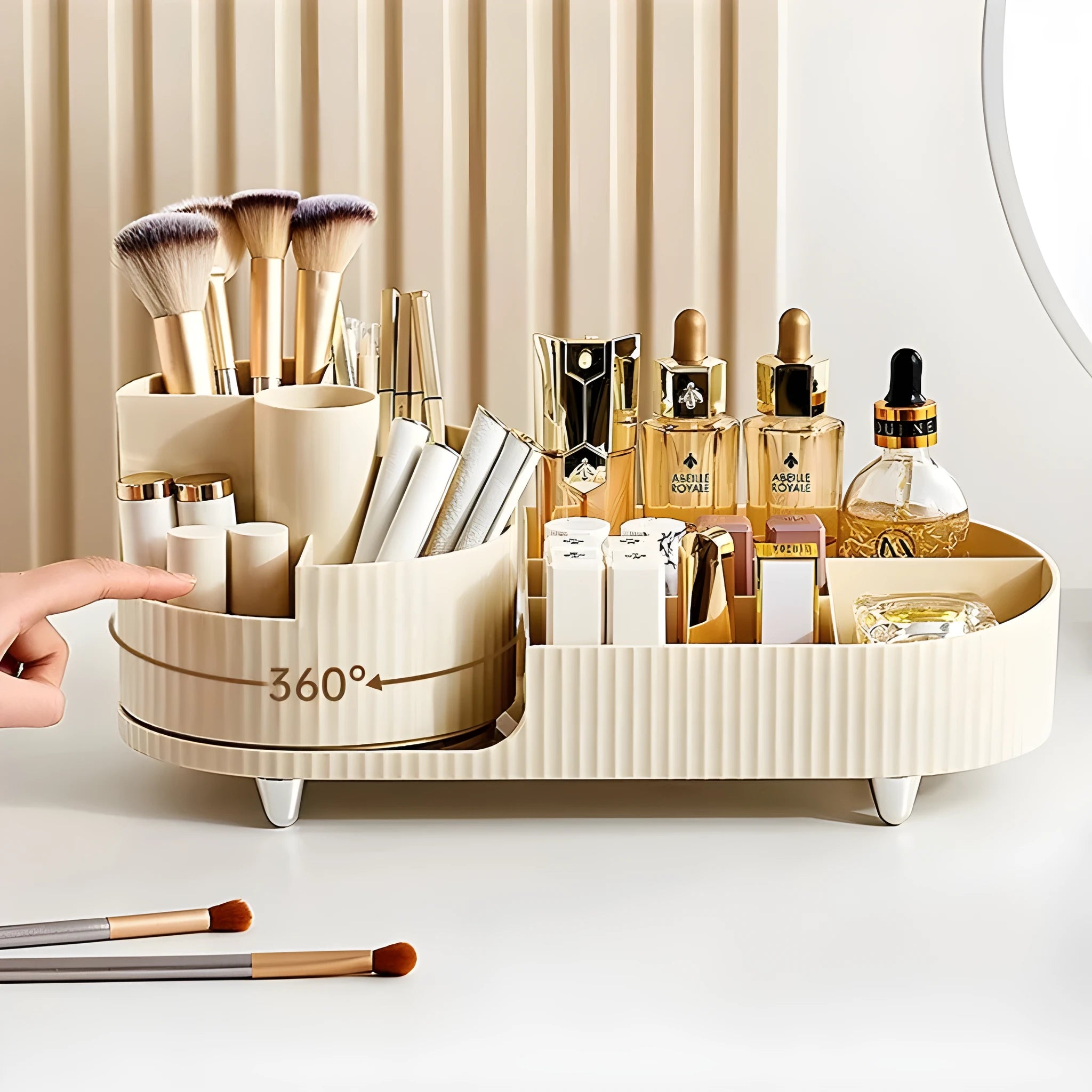 Rotating cream and black cosmetics organiser box holding makeup brushes and lipsticks on a table.