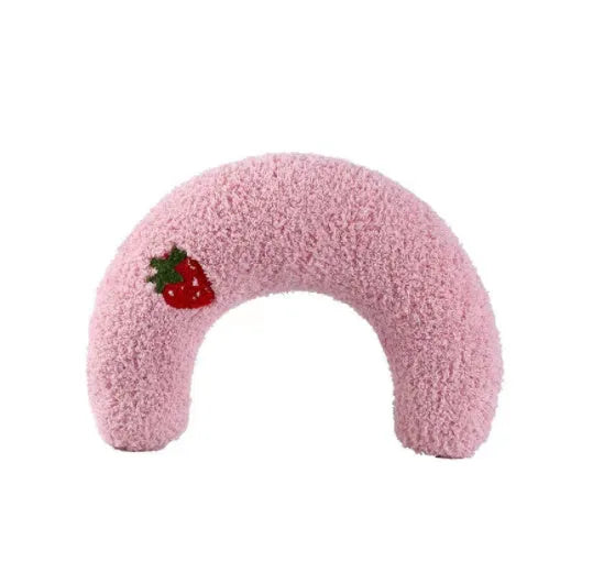Small white half-donut U-shaped plush pillow for a cat or small dog on a carpet