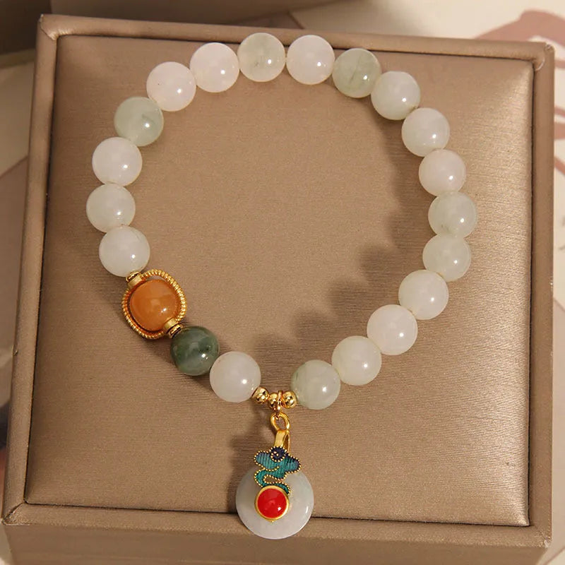 Women's ice jade bracelet with xiangyun pattern, peace buckle, and pearl accents on a white background.