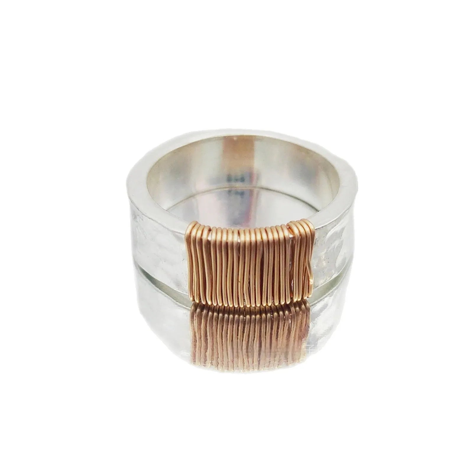 Copper wide face geometric ring bracelet in silver gold coil colour on a plain background.