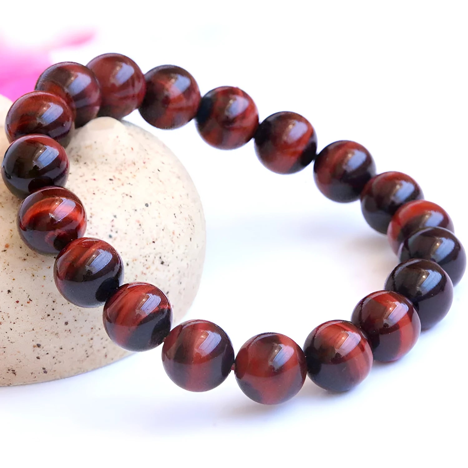 Red tigereye wood alexandrite bracelet with lightning cat's eye pattern on wrist.