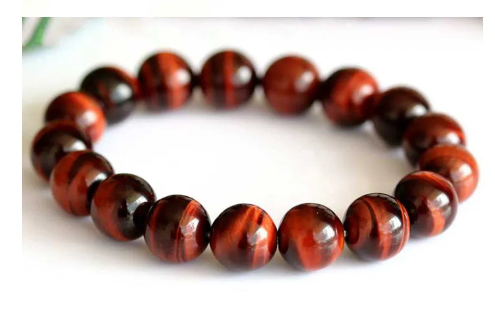 Red tigereye wood alexandrite bracelet with lightning cat's eye pattern on wrist.