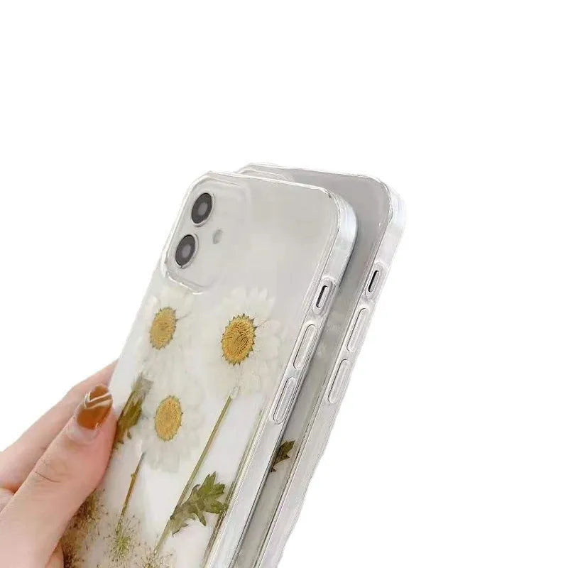 White TPU iPhone case with epoxy daisy floral design on back, shown fitted to a phone