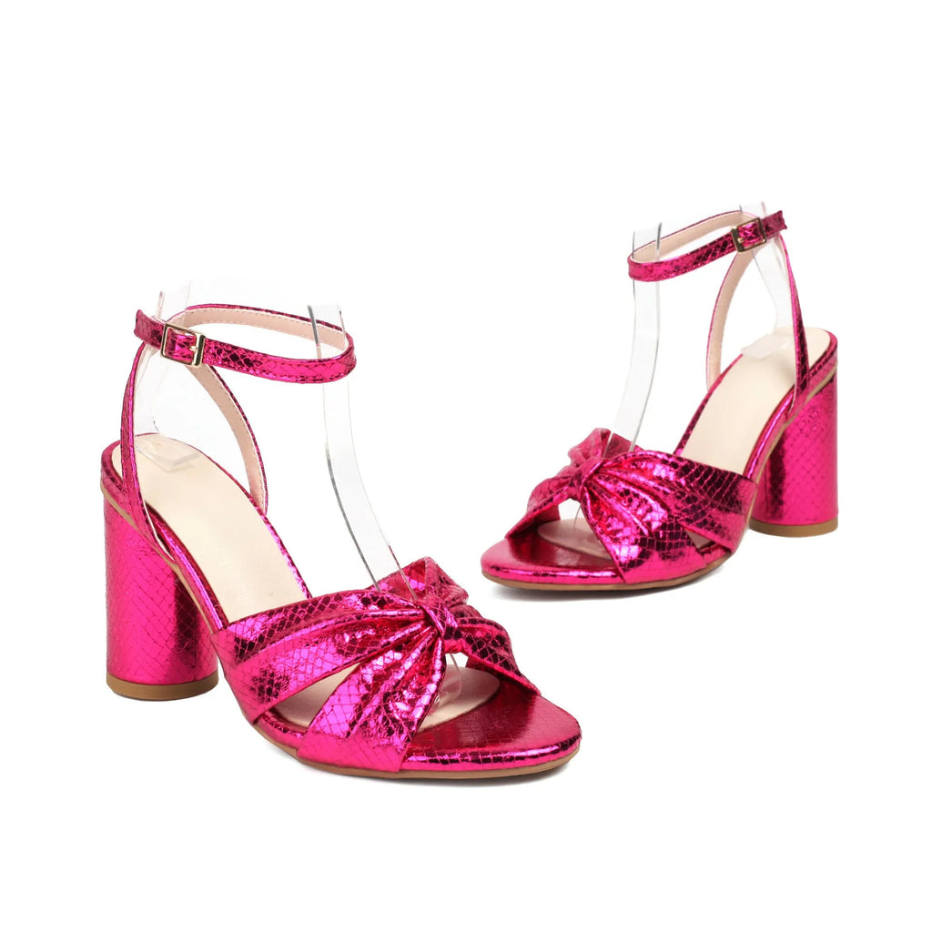 Gold high heel peep toe sandal with ankle buckle on a white background