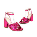 Gold high heel peep toe sandal with ankle buckle on a white background