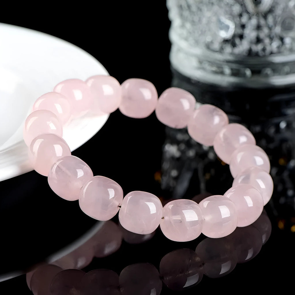 Pink crystal barrel bead bracelet with geometric design on a wrist.