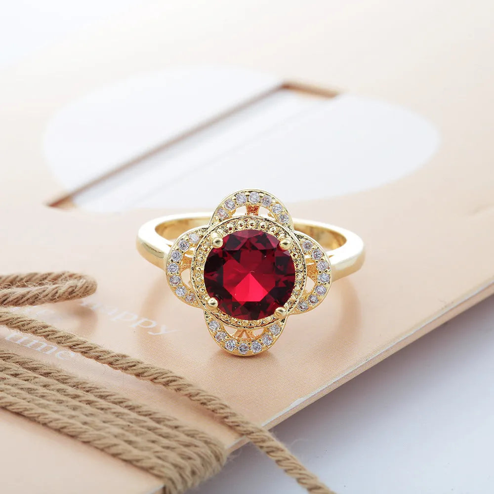 Copper fruit-shaped ring with a central zircon inlay on a model's finger.