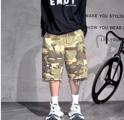 Man wearing loose fit camouflage retro workwear shorts in a khaki camouflage pattern.