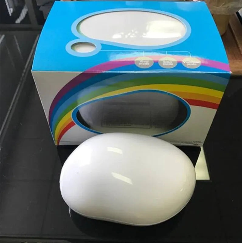 Egg-shaped white rainbow projection lamp with three lighting modes, 14x10x6cm, on a table