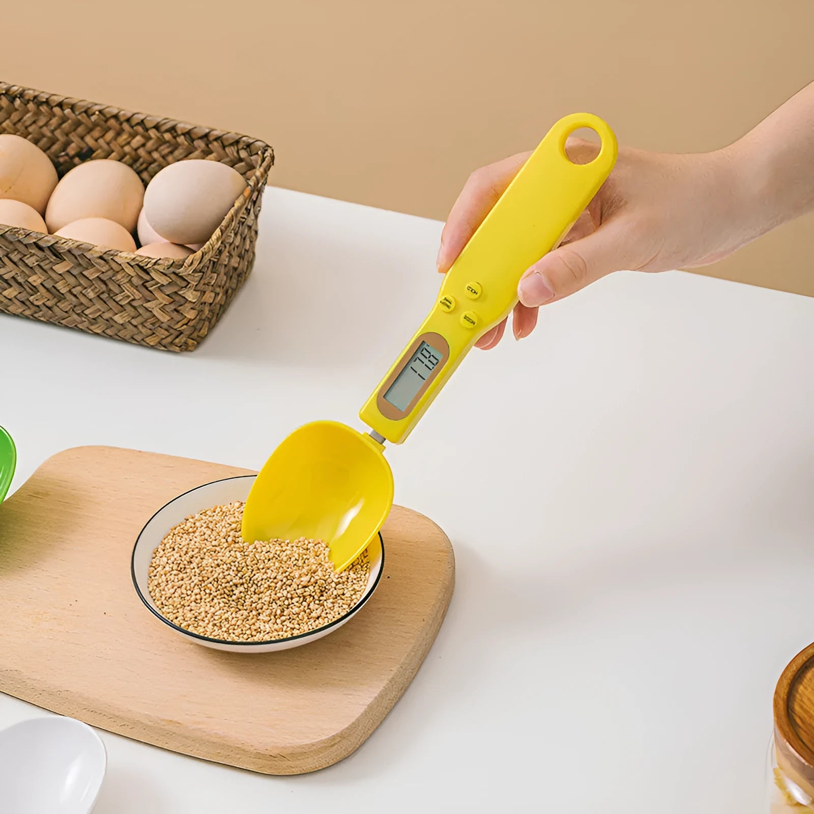 White electronic digital spoon scale with LCD display on a kitchen counter.