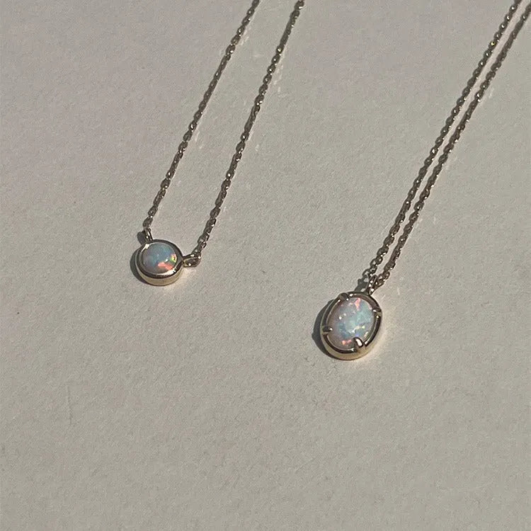 S925 sterling silver necklace with a geometric pendant holding a round jelly opal, plated in gold.