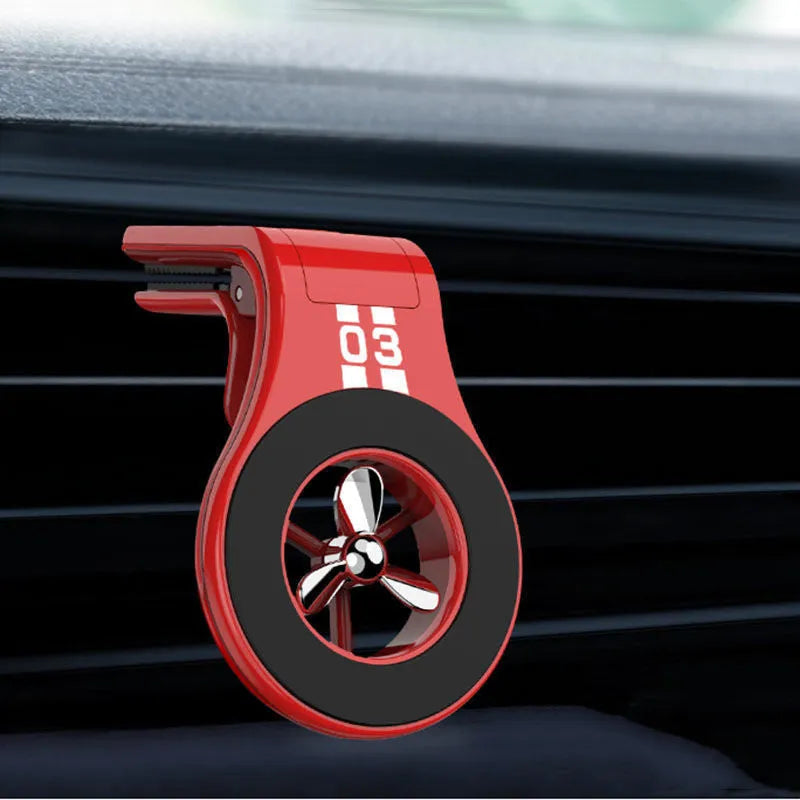 Black magnetic car air vent phone holder with adjustable head and fragrance slices attached to a vehicle vent.
