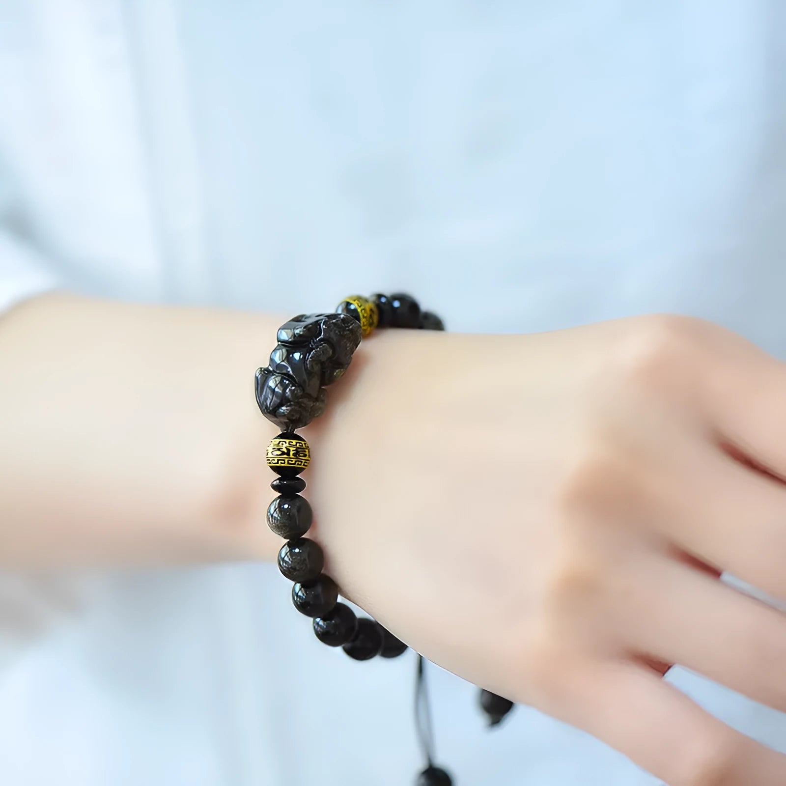 Original hand-woven golden obsidian Pi Xiu bracelet showing bead detail and Chinese style design