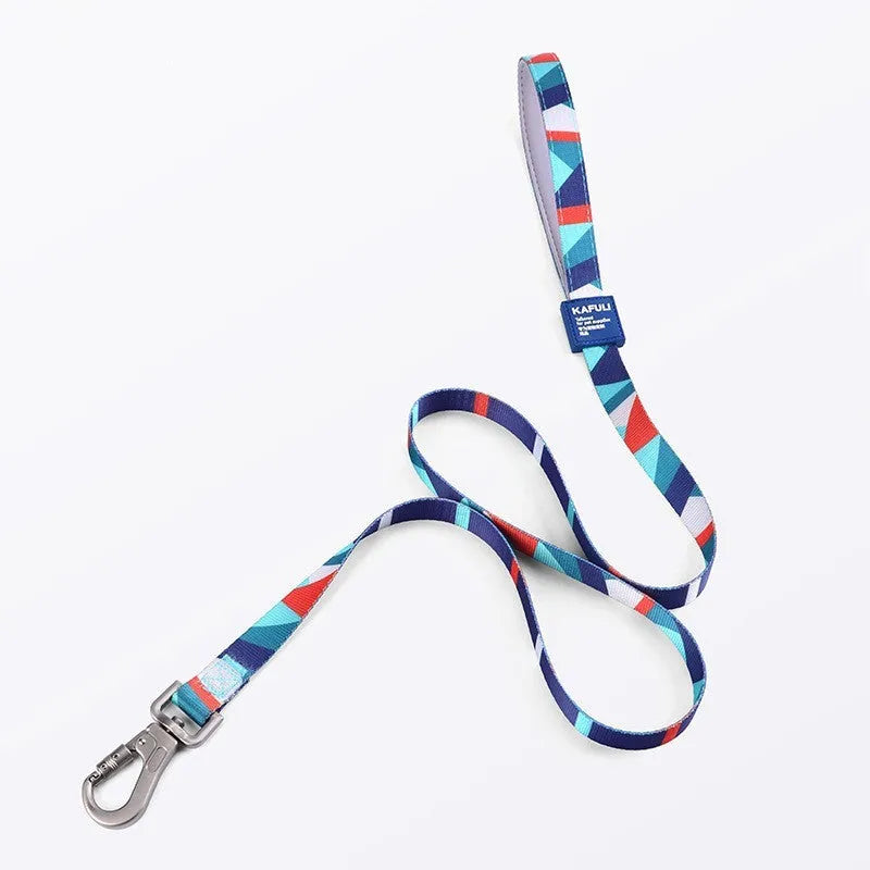 Blue polyester dog harness vest connected to a matching haulage rope on a grassy background.