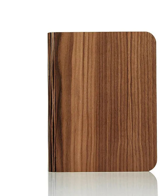 Solid wood book light with USB cable on a desk next to a book.