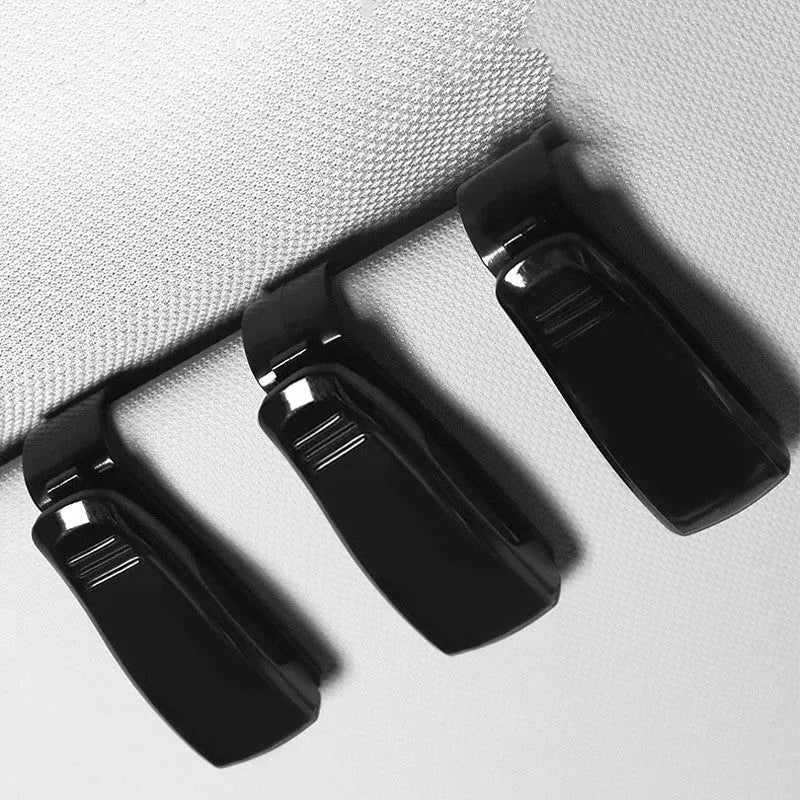 Black plastic clip for car sunshade to hold sunglasses and tickets.