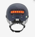 Adult cycling helmet with integrated red LED tail light on the back, shown in M and L sizes.