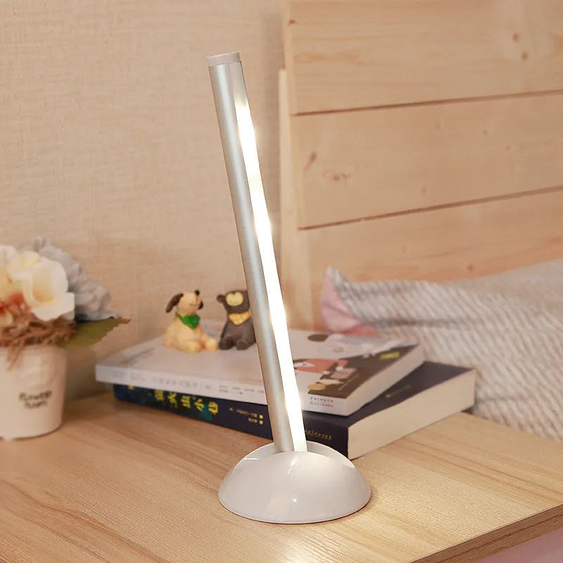 White LED cabinet night light unit with remote control on a table.