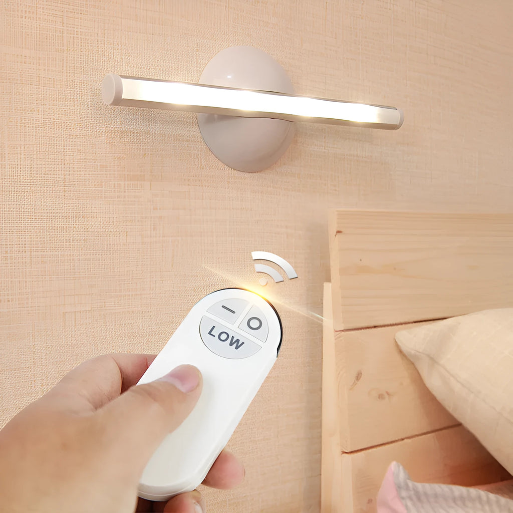 White LED cabinet night light unit with remote control on a table.