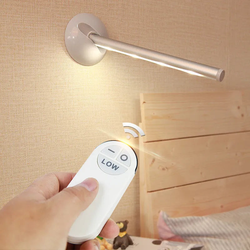 White LED cabinet night light unit with remote control on a table.