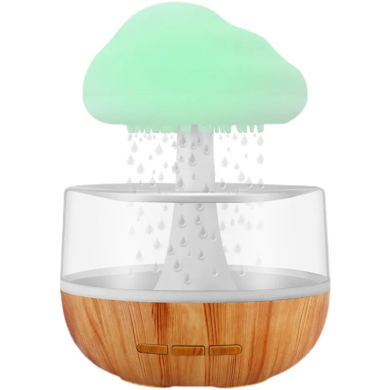 White cloud-shaped humidifier with multi-colour night light on a table.
