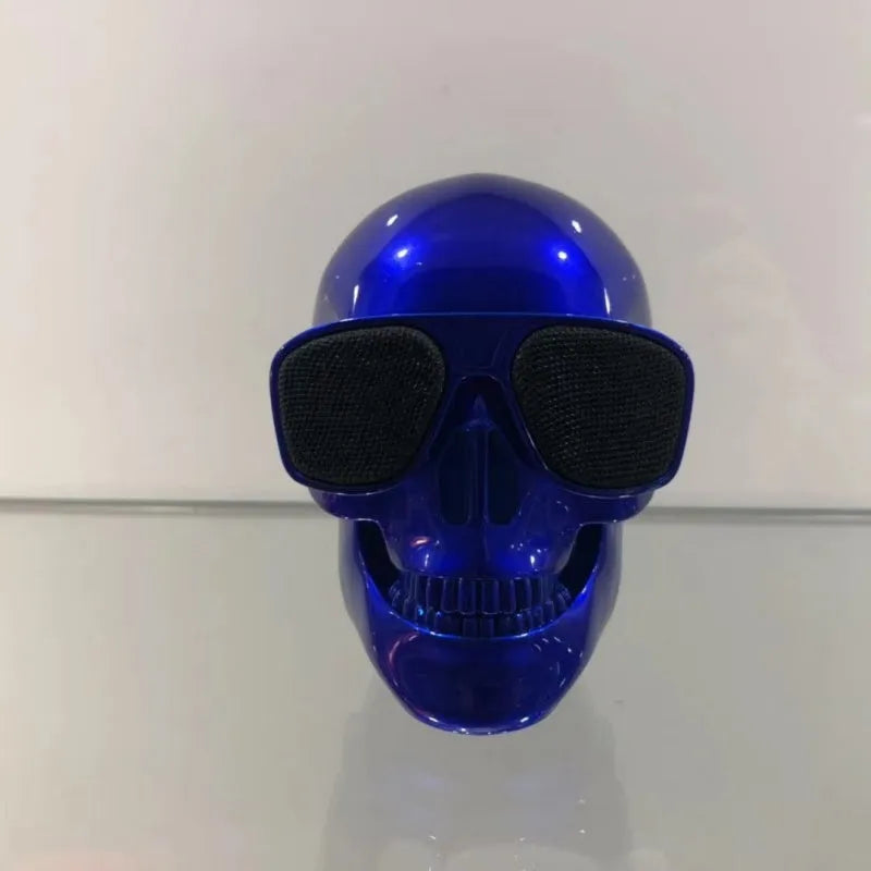 Small skull-shaped wireless Bluetooth speaker in black, portable with button controls and USB charging