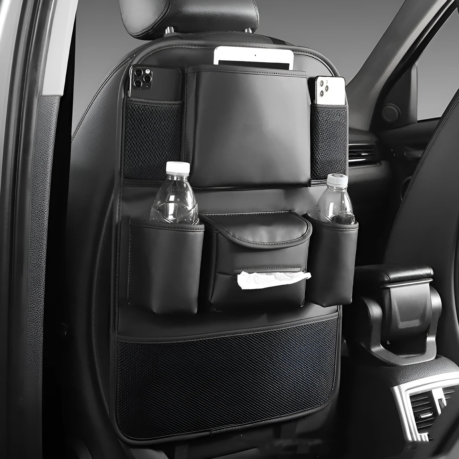 Leather car seat back storage bag in black, suspended behind a car headrest.