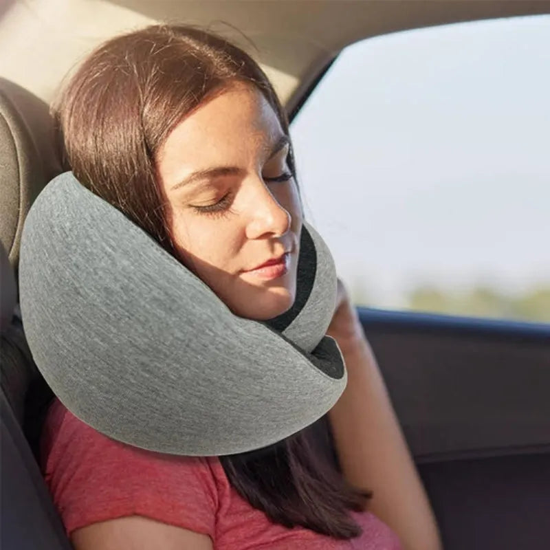 Navy blue U-shaped travel neck pillow with memory foam, shown rolled up next to its carry bag.