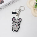 Close-up of a sparkling cartoon dog keychain pendant with rhinestones on an alloy base.