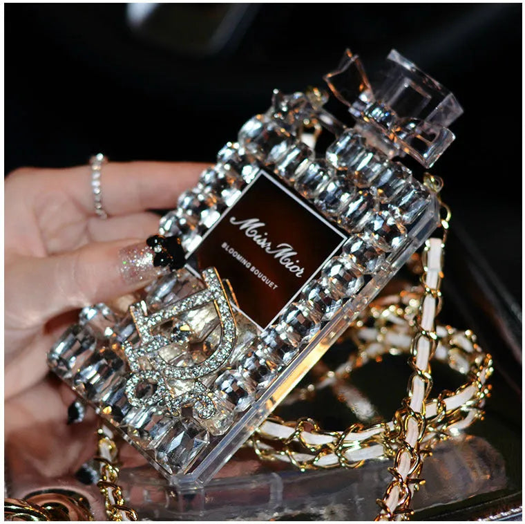 Perfume bottle bow design iPhone case with a metal chain strap in black, gold, pink, or transparent colours.