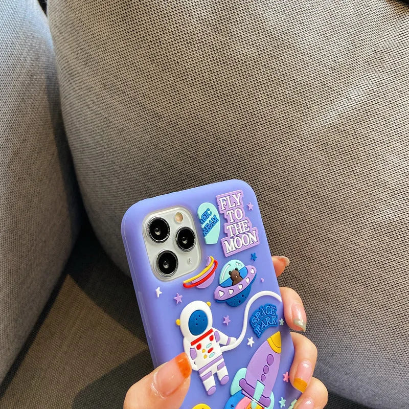 Purple silicone iPhone case with a cartoon astronaut design, shown fitted on a phone.