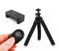 Black flexible octopus tripod with coiled legs next to a smartphone, showing its 18cm size.