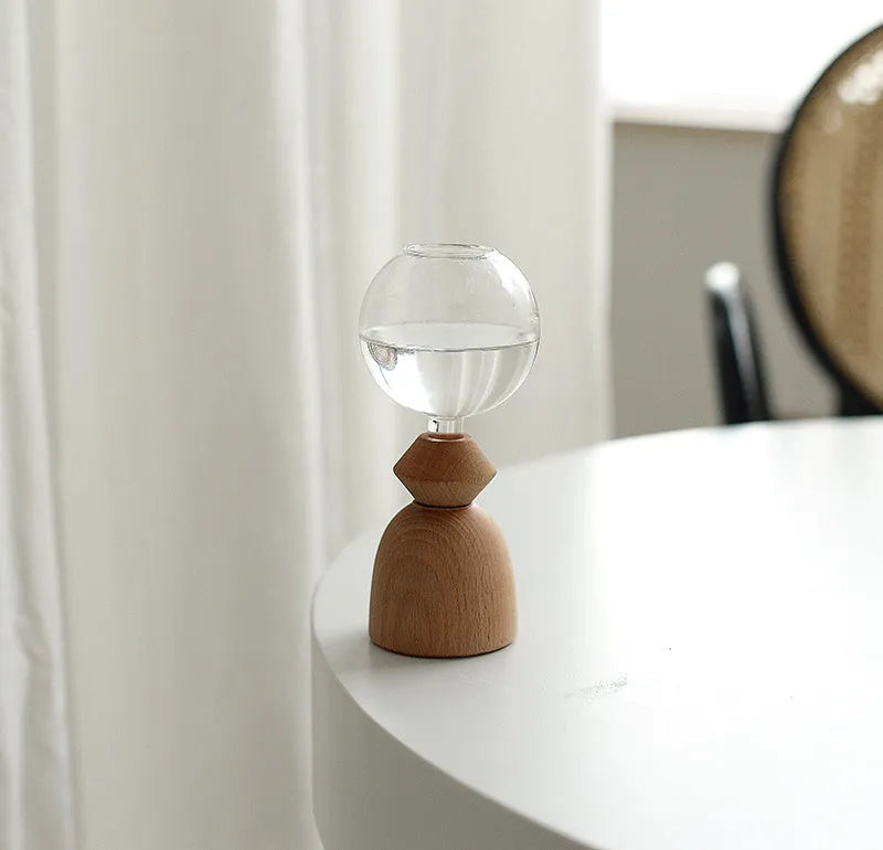 Geometric clear glass bubble vase on wooden base with conical or arc bottom designs