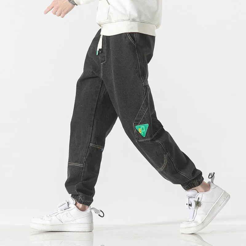 Men's loose-fit tapered cotton trousers in mid-waist design, shown in black colour.