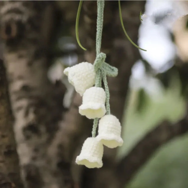 Green and white knitted wool car plant decoration with 25cm hanging rope on a car dashboard