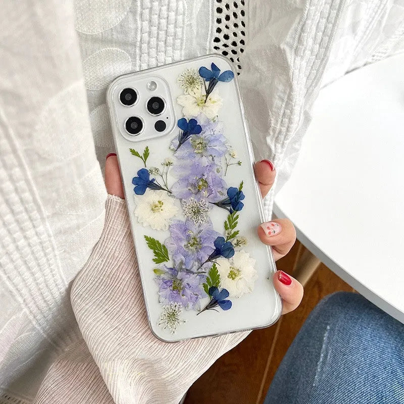 Soft blue and purple dried floral bouquet design on a transparent TPU case for an iPhone.