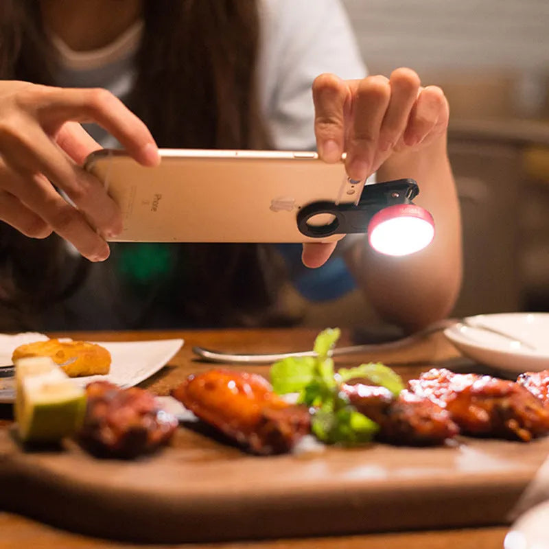 Universal smartphone camera lens attachment kit with wide-angle, macro, and fisheye lenses, LED lights, and a tripod grip.