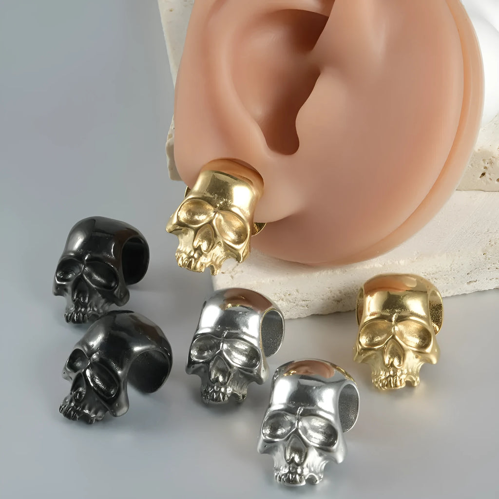 Stainless steel hollow geometric earrings combining a skull with a Buddha head motif.