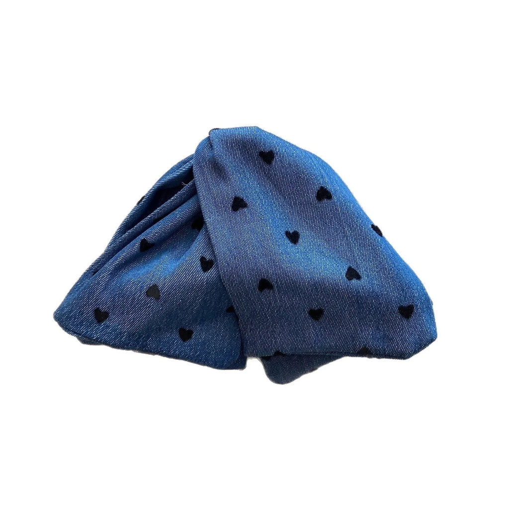 Close-up of a handmade hair clip with a denim bow and clear triangle acrylic grip.