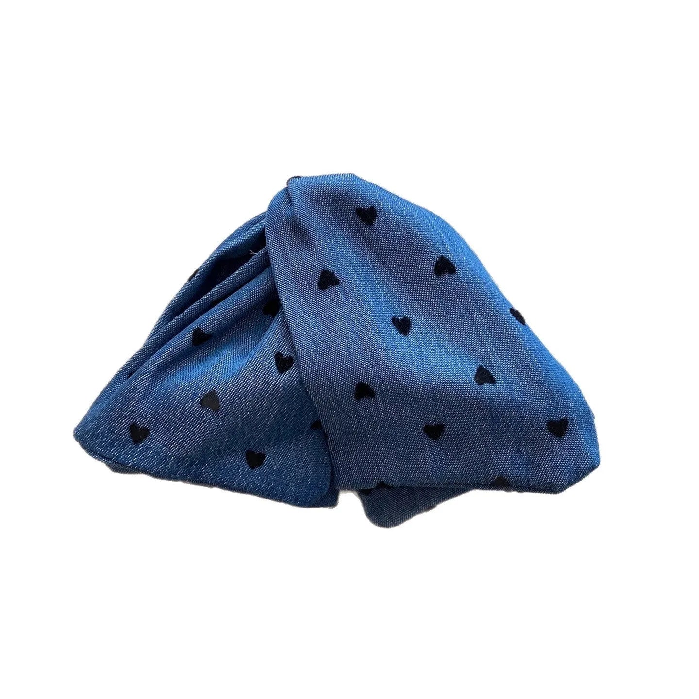 Close-up of a handmade hair clip with a denim bow and clear triangle acrylic grip.
